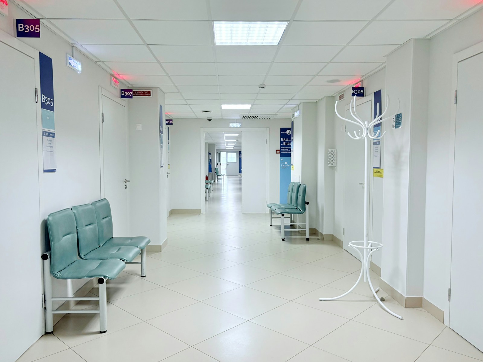 Hospital corridor with patient seating and treatment-room access